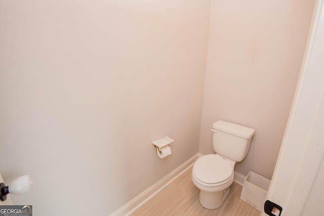 bathroom with toilet and baseboards