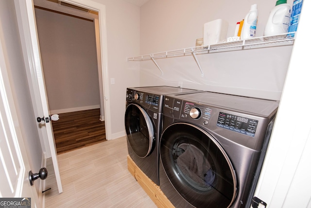 laundry room with visible vents, baseboards, washer and clothes dryer, laundry area, and light wood-style flooring