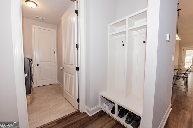 mudroom featuring wood finished floors, visible vents, and baseboards