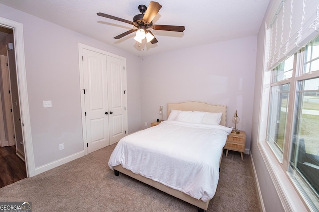 bedroom with a closet, baseboards, carpet, and a ceiling fan