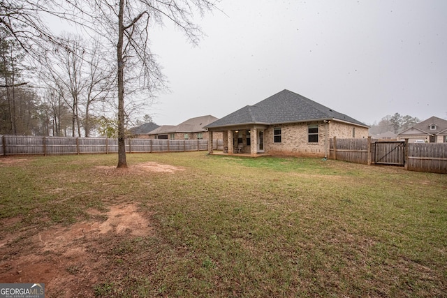 view of yard with a fenced backyard and a gate