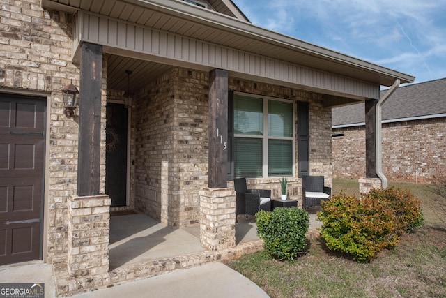 doorway to property with stone siding, brick siding, and a porch