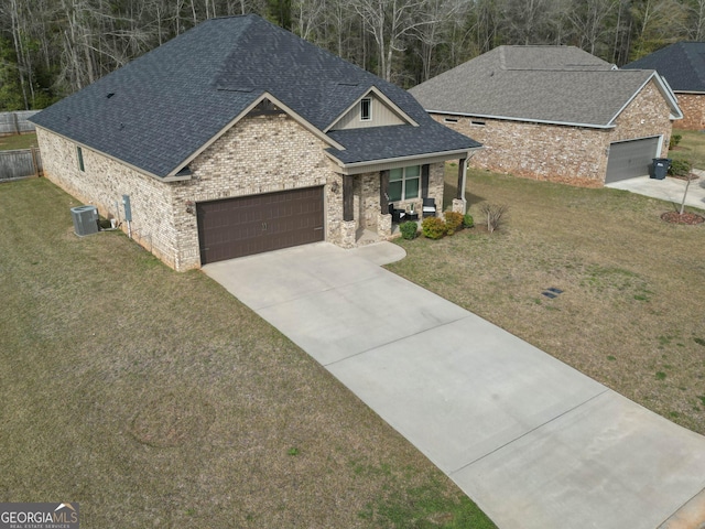 view of front of home featuring a front lawn, roof with shingles, central AC unit, a garage, and driveway