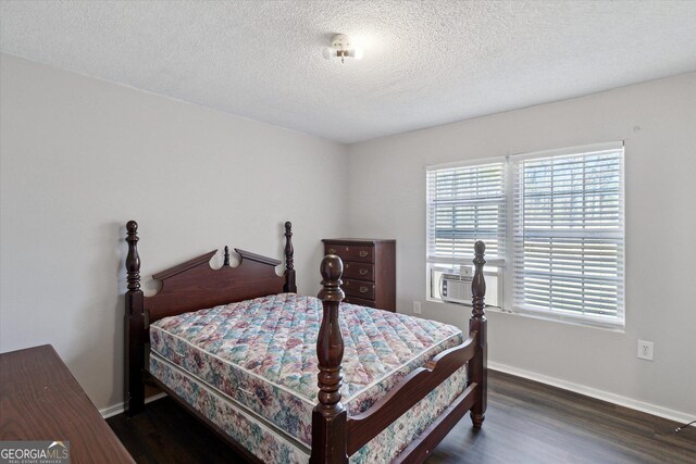 97 Meadow Rd, Swainsboro, GA 30401 - bedroom with cooling unit, dark wood-style floors, baseboards, and a textured ceiling