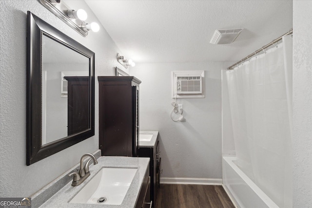 97 Meadow Rd, Swainsboro, GA 30401 - full bath featuring visible vents, a wall mounted air conditioner, vanity, wood finished floors, and a textured ceiling