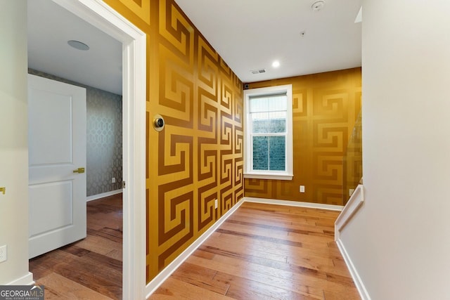hall with light wood-style floors and baseboards