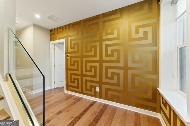 hall featuring light wood-style floors and visible vents