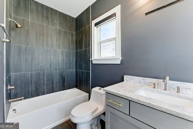 bathroom with toilet, wood finished floors, vanity, and shower / bathtub combination