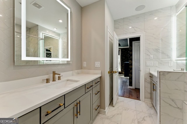 bathroom with visible vents, a shower, marble finish floor, and vanity