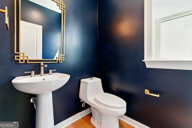 bathroom featuring baseboards and toilet