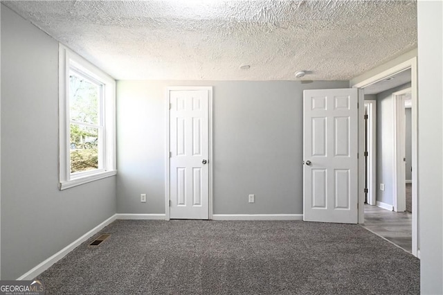 6886 Upshaw Mill Rd, Douglasville, GA 30134 - unfurnished bedroom featuring a textured ceiling, carpet flooring, and baseboards