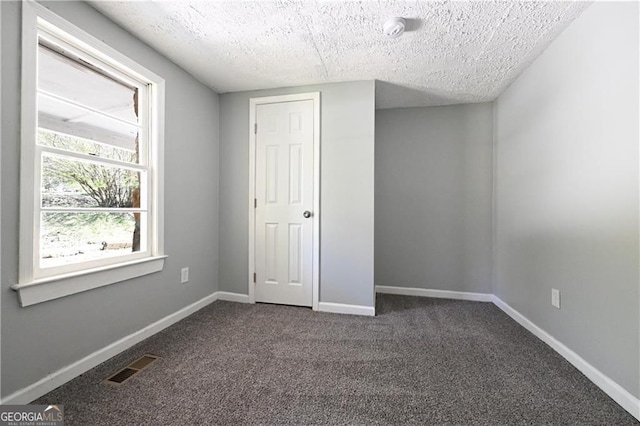 6886 Upshaw Mill Rd, Douglasville, GA 30134 - unfurnished bedroom with dark colored carpet, a textured ceiling, and baseboards