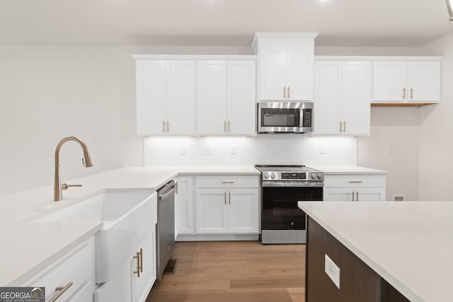 2219 Nena Way Unit 22, Tucker, GA 30084 - kitchen featuring white cabinets, light wood-style flooring, and appliances with stainless steel finishes