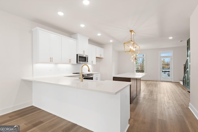 2219 Nena Way Unit 22, Tucker, GA 30084 - kitchen featuring stainless steel microwave, a center island, light countertops, light wood-type flooring, and white cabinetry