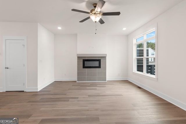 2219 Nena Way Unit 22, Tucker, GA 30084 - unfurnished living room featuring a tile fireplace, baseboards, light wood-style floors, and a ceiling fan