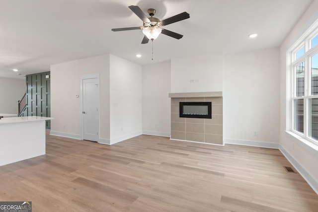 2219 Nena Way Unit 22, Tucker, GA 30084 - unfurnished living room with light wood-type flooring, visible vents, stairway, ceiling fan, and a tile fireplace