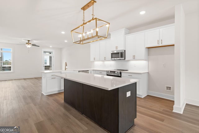 2219 Nena Way Unit 22, Tucker, GA 30084 - kitchen with light wood finished floors, appliances with stainless steel finishes, light countertops, and a peninsula