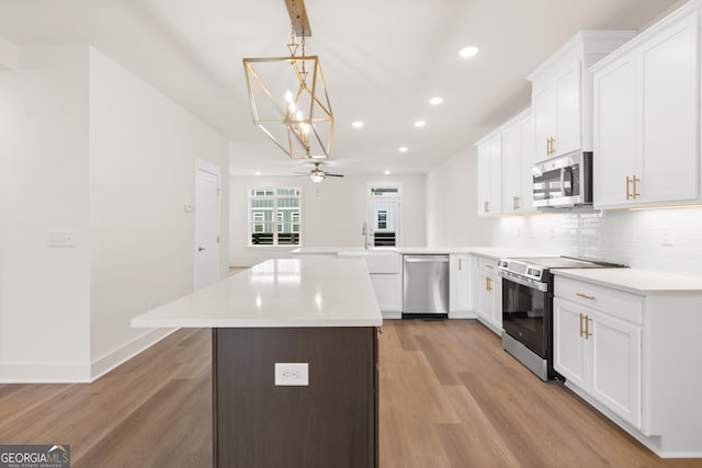 2219 Nena Way Unit 22, Tucker, GA 30084 - kitchen with decorative backsplash, a peninsula, light wood-type flooring, and appliances with stainless steel finishes