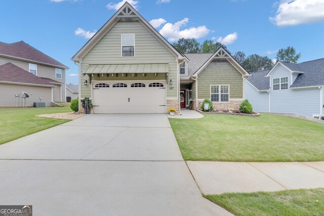craftsman inspired home featuring stone siding, a front yard, driveway, and cooling unit