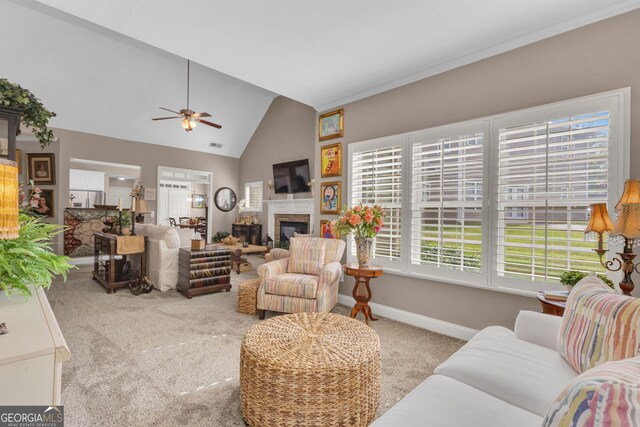 living room featuring carpet, vaulted ceiling, a ceiling fan, a glass covered fireplace, and baseboards