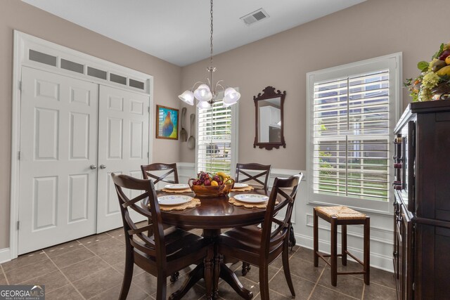 dining room featuring tile patterned flooring and a chandelier