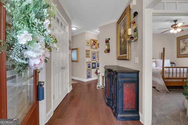 sitting room with carpet flooring, crown molding, and baseboards