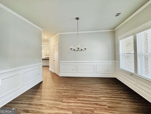 61 Observation Way, Dallas, GA 30132 - unfurnished dining area featuring a chandelier, crown molding, wood finished floors, a wainscoted wall, and a decorative wall