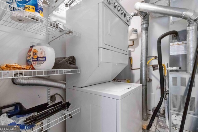 laundry area featuring stacked washing maching and dryer and laundry area