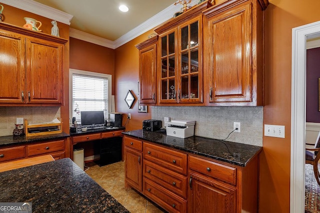 36 Blackthorn Ln, Colbert, GA 30628 - kitchen with brown cabinetry, backsplash, glass insert cabinets, dark stone counters, and ornamental molding