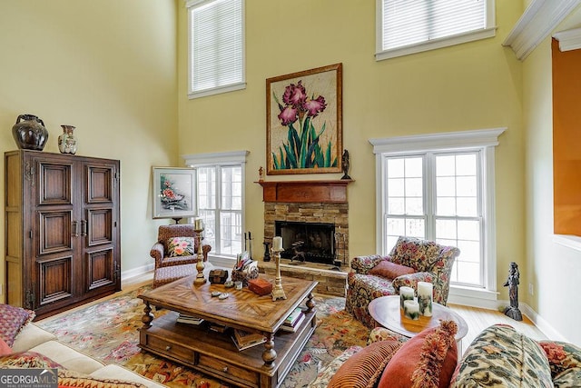 36 Blackthorn Ln, Colbert, GA 30628 - living room featuring a towering ceiling, a fireplace, baseboards, wood finished floors, and healthy amount of natural light