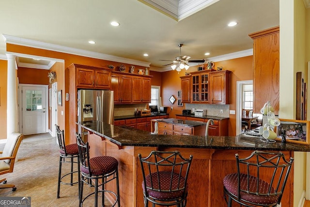 36 Blackthorn Ln, Colbert, GA 30628 - kitchen with stainless steel fridge with ice dispenser, recessed lighting, a peninsula, brown cabinetry, and a breakfast bar area