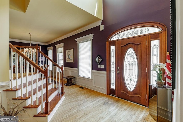 36 Blackthorn Ln, Colbert, GA 30628 - foyer featuring wood-type flooring, a chandelier, stairway, wainscoting, and ornamental molding