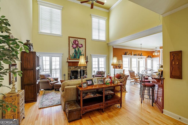 36 Blackthorn Ln, Colbert, GA 30628 - living room with a ceiling fan, light wood-type flooring, a stone fireplace, a high ceiling, and crown molding