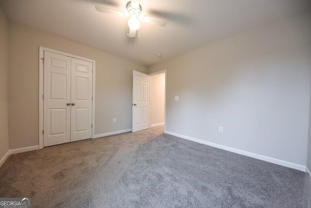 unfurnished bedroom featuring baseboards, a ceiling fan, a closet, and carpet