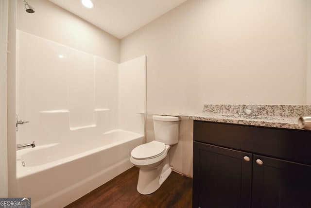 bathroom featuring toilet, vanity, tub / shower combination, and wood finished floors