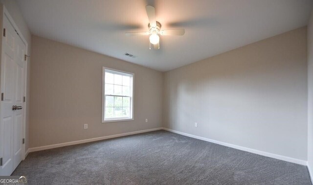 spare room with carpet, baseboards, ceiling fan, and visible vents