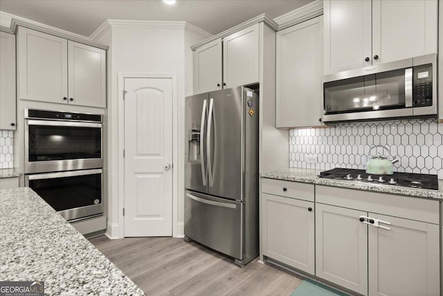 372 Garnet Dr, Acworth, GA 30101 - kitchen with stainless steel appliances, light wood-style floors, decorative backsplash, crown molding, and gray cabinetry