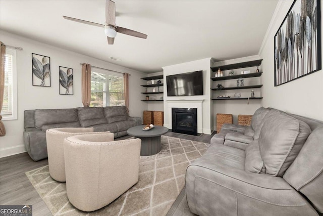 372 Garnet Dr, Acworth, GA 30101 - living area with light wood-style flooring, a glass covered fireplace, a ceiling fan, ornamental molding, and baseboards