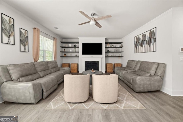 372 Garnet Dr, Acworth, GA 30101 - living room featuring ceiling fan, light wood-style floors, crown molding, a glass covered fireplace, and baseboards