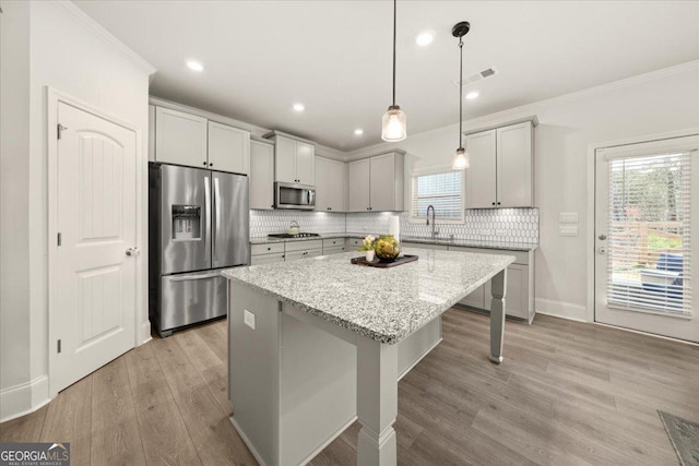 372 Garnet Dr, Acworth, GA 30101 - kitchen featuring appliances with stainless steel finishes, a sink, ornamental molding, a center island, and tasteful backsplash