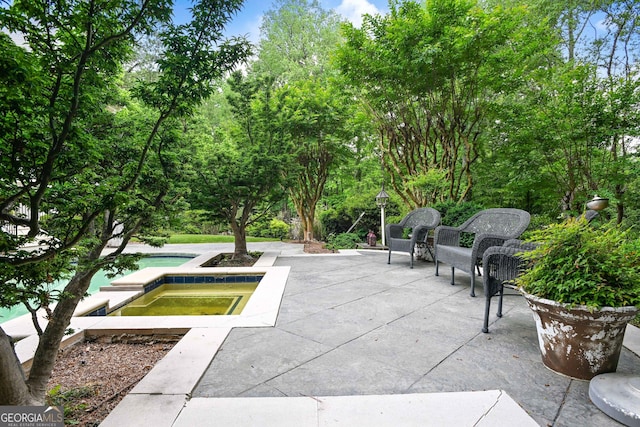 view of property's community with a swimming pool, a jacuzzi, and a patio area