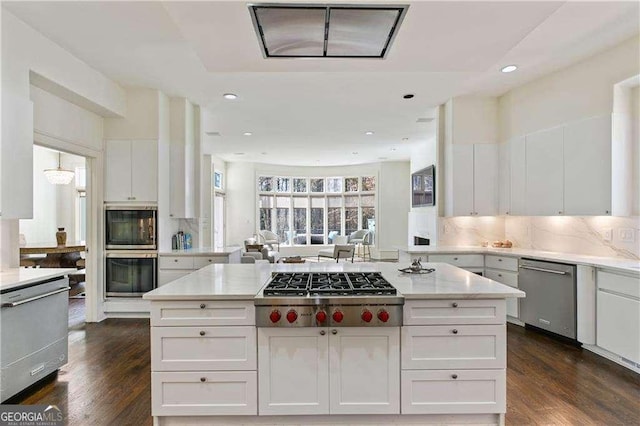 kitchen with white cabinets, backsplash, stainless steel appliances, and dark wood-style flooring
