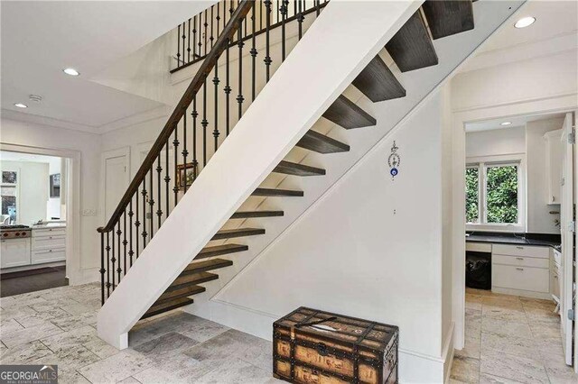 stairs featuring stone tile floors and recessed lighting