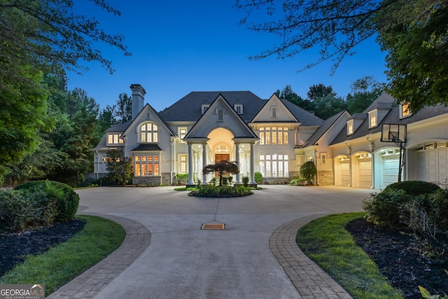 510 Covington Cv, Alpharetta, GA 30022 - view of front of home featuring stone siding, curved driveway, a chimney, and stucco siding