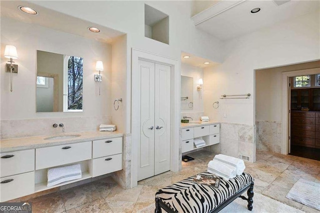 full bath with recessed lighting, tile walls, and vanity