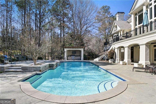 view of pool featuring a pool with connected hot tub and a patio area