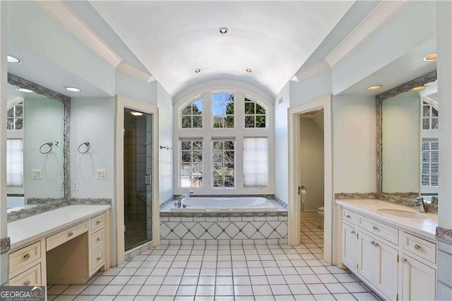 bathroom featuring vanity, toilet, a shower stall, lofted ceiling, and a garden tub