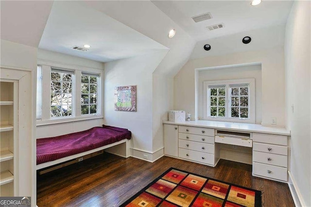 bedroom with dark wood-type flooring, built in study area, and visible vents