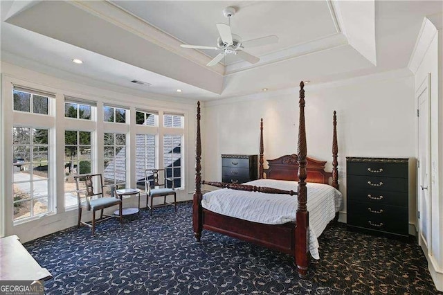 bedroom with carpet floors, multiple windows, ornamental molding, and a raised ceiling
