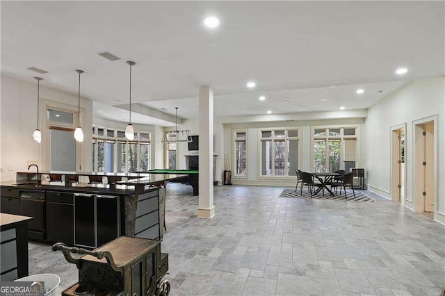 interior space featuring a sink, stone tile floors, recessed lighting, baseboards, and visible vents